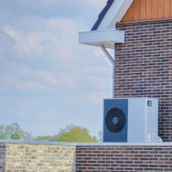 air source heat pump unit installed outdoors at a modern home with bricks in the Netherlands at spring, warmte pomp translation air source heat pump , energy transition in Europe